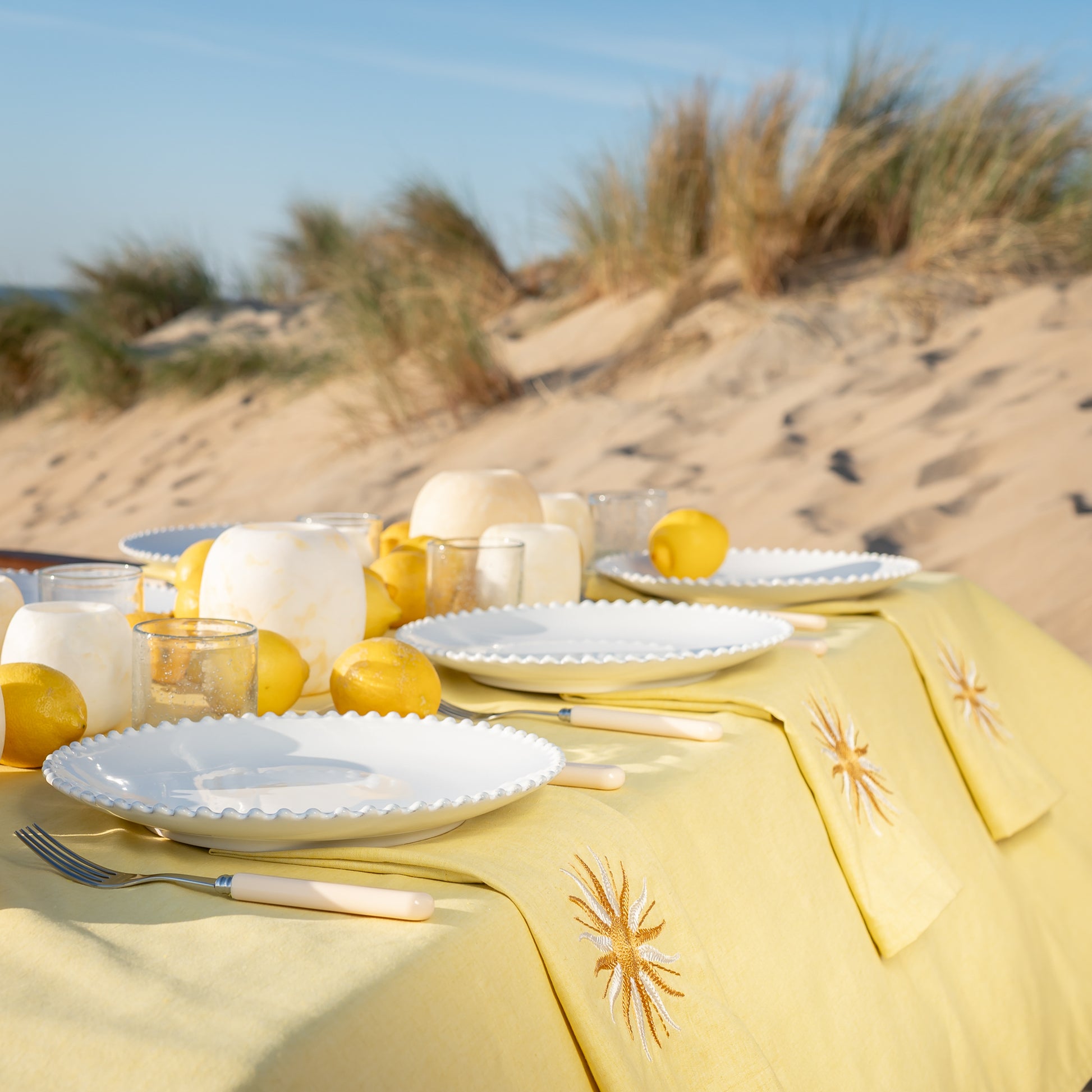 Botergeel tafelkleed met geborduurde servetten voorzien van zon en borden Pearl van Costa Nova